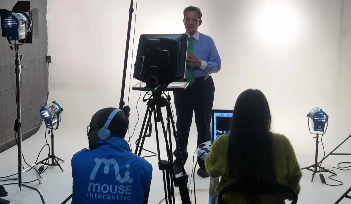Equipo de producción audiovisual grabando en estudio con teleprompter y set de iluminación